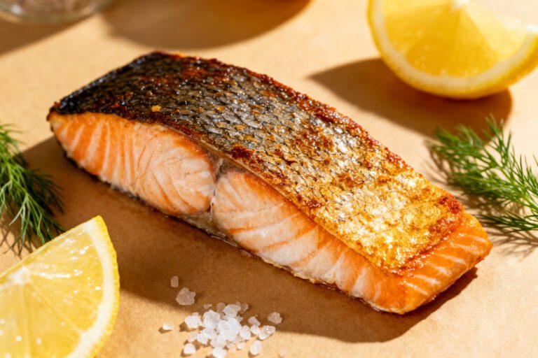 Air fryer crispy skin salmon with a flaky tender salmon fillet, extra crispy golden skin, fresh dill, lemon wedges, and flaky sea salt, served as a flavorful and healthy seafood dinner.