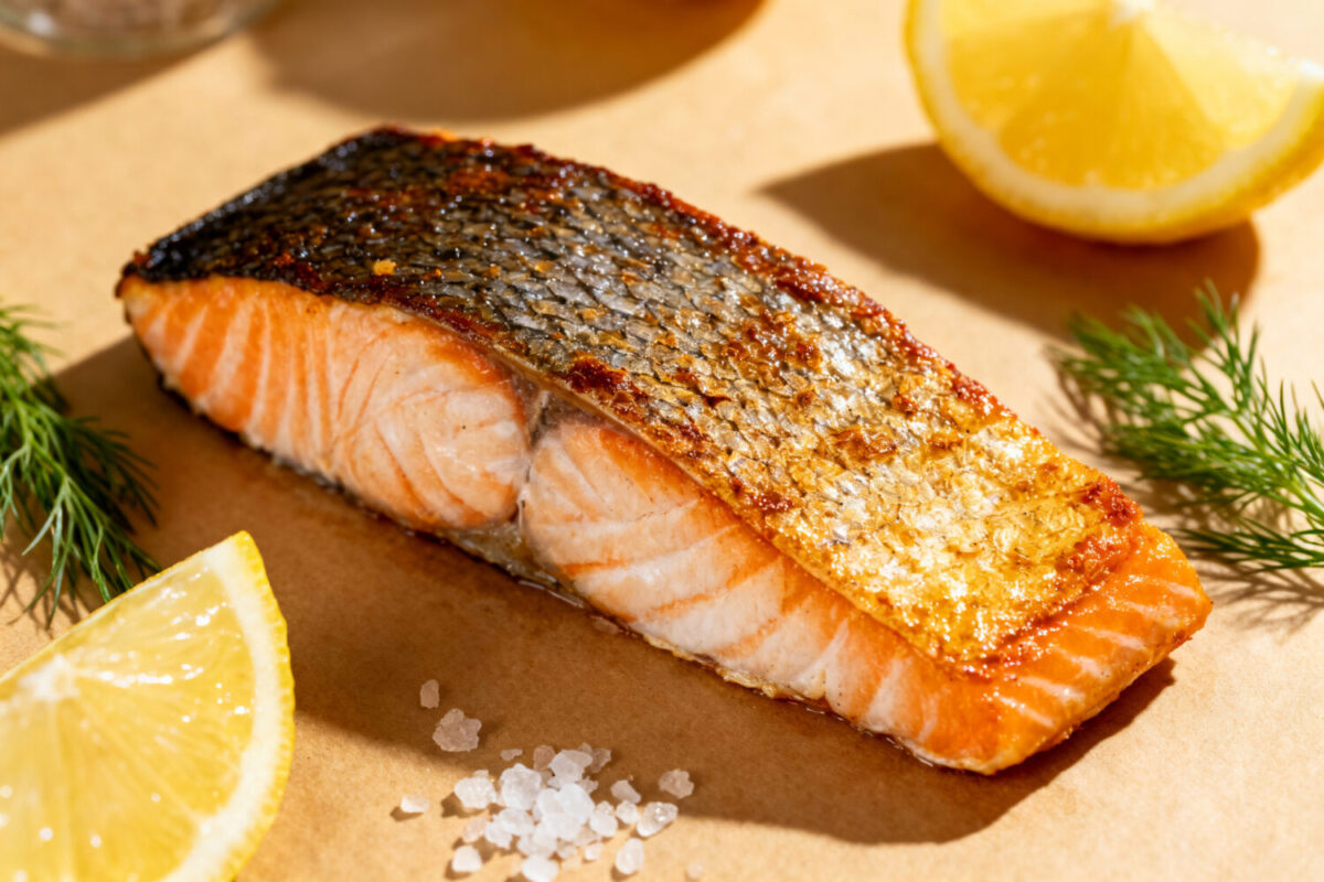 Air fryer crispy skin salmon with a flaky tender salmon fillet, extra crispy golden skin, fresh dill, lemon wedges, and flaky sea salt, served as a flavorful and healthy seafood dinner.