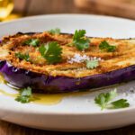Healthy air fryer eggplant with tender roasted eggplant halves, caramelized golden surface, flaky sea salt, fresh parsley, and olive oil, served as a light and flavorful vegetable side dish.