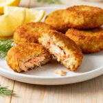 Air fryer salmon croquettes with crispy golden breadcrumb coating, tender flaky salmon filling, fresh dill, and lemon wedges, served as a flavorful seafood appetizer or weeknight dinner.