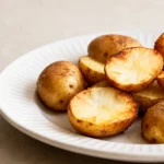 Russet potatoes cooked in the air fryer with crispy golden brown skins, fluffy tender interiors, and roasted edges, served on a plate as a simple and satisfying side dish.