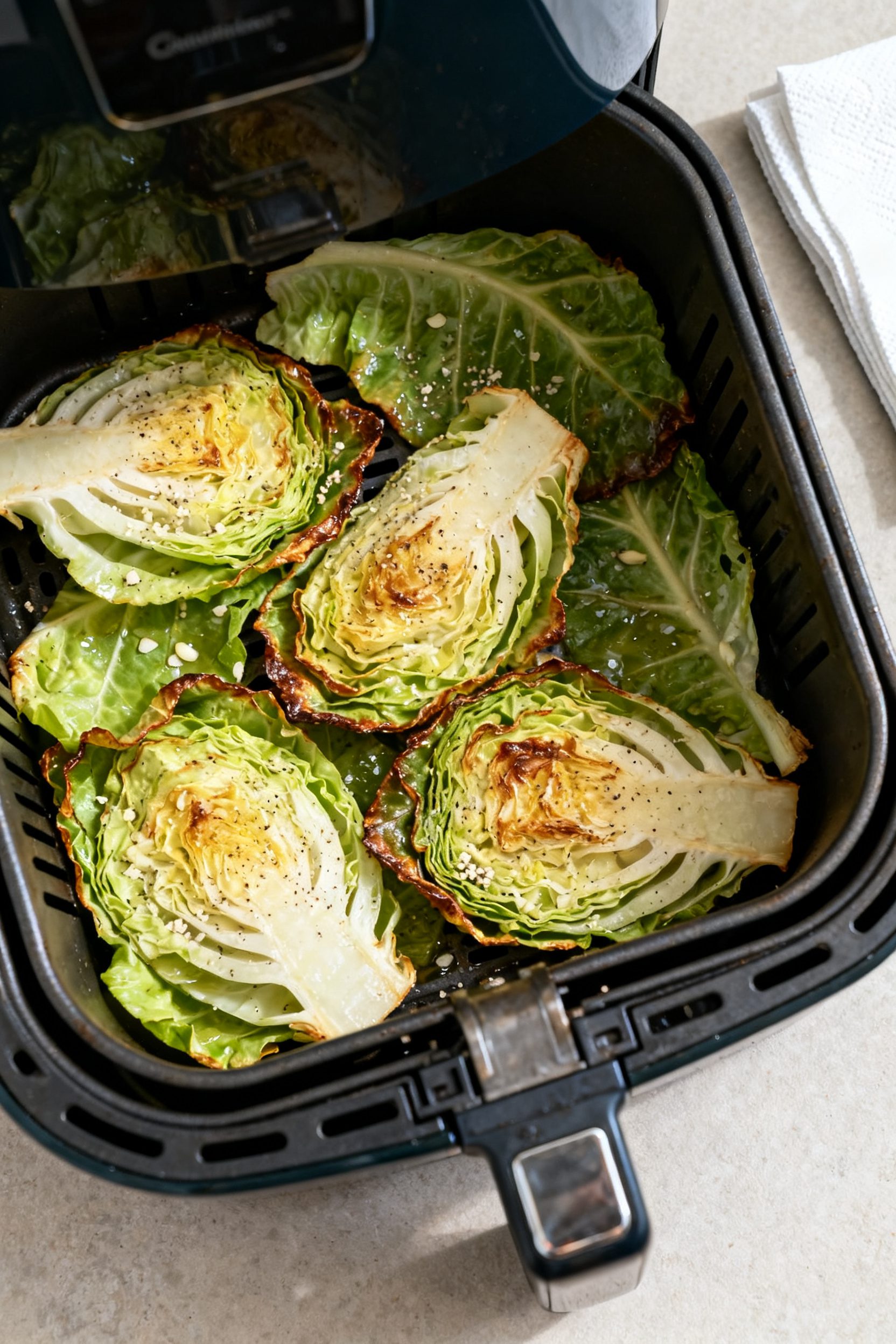 Cooking process: Overhead shot of an air fryer drawer loaded in a single, loose layer of seasoned ca
