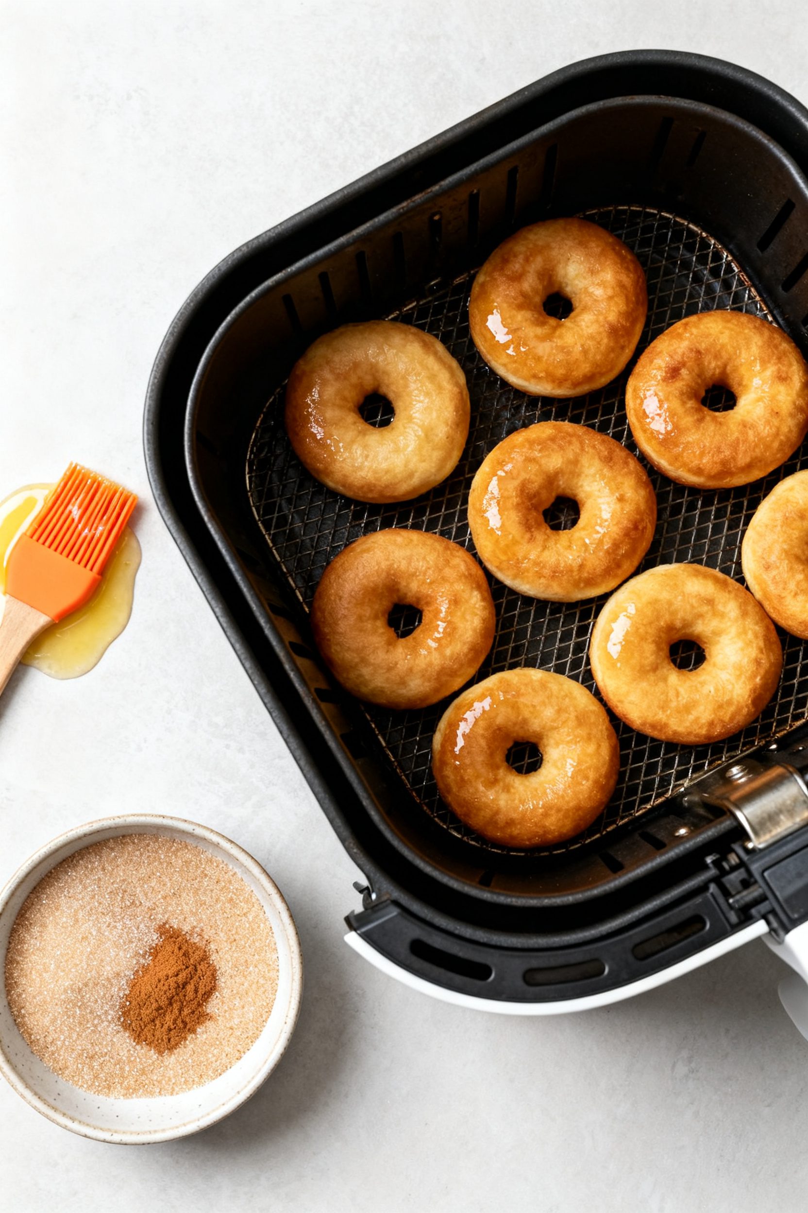 Cooking process: Overhead shot of golden donuts resting in an open air fryer basket at 350°F, mid-b