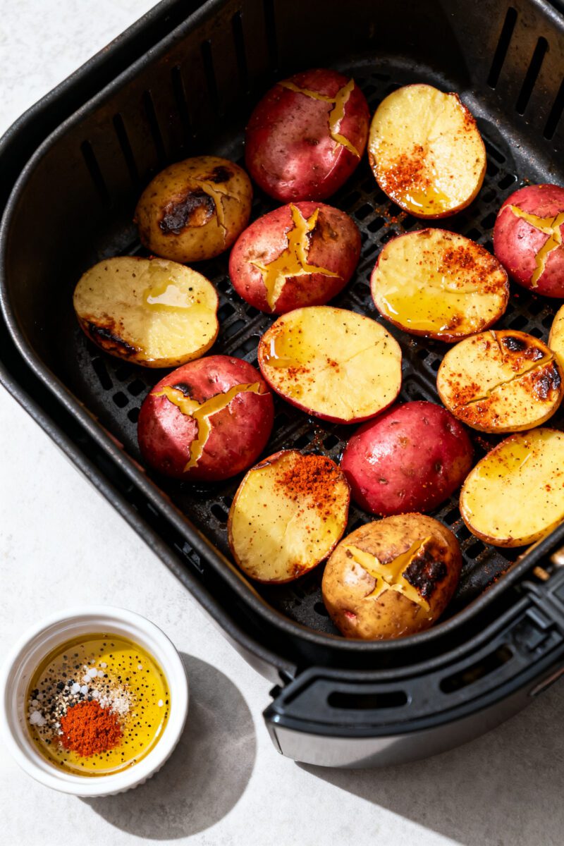 Cooking process: Overhead shot of smashed baby gold and red potatoes arranged in a single layer in a