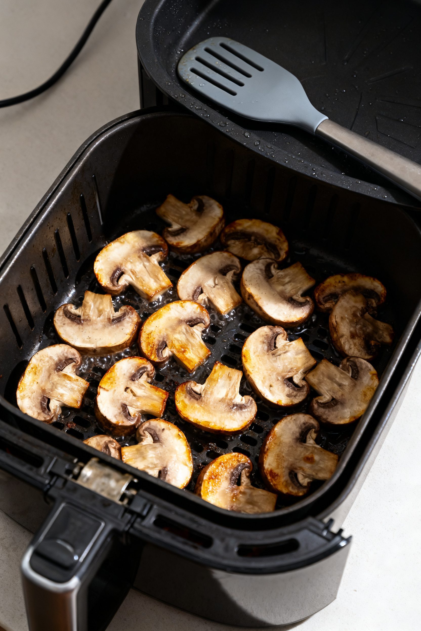 Cooking process shot: Overhead view inside an open air fryer at 380°F showing a single, uncrowded l