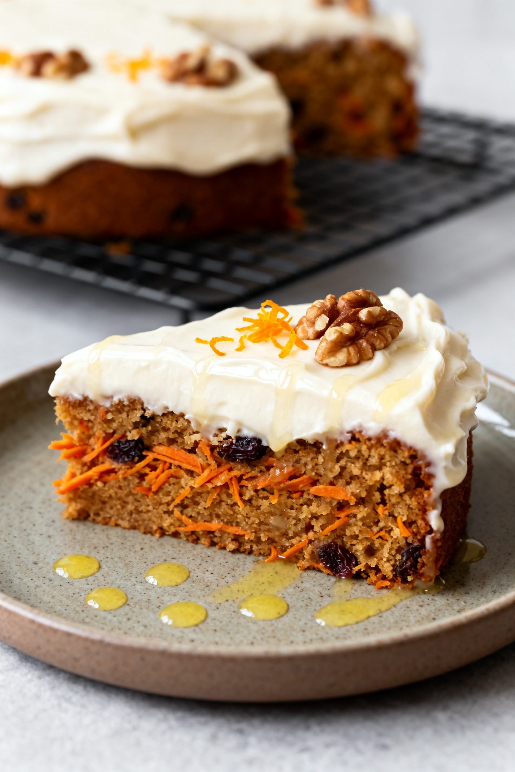 Final plated presentation: A generous slice of carrot cake on a matte ceramic plate, cream cheese fr