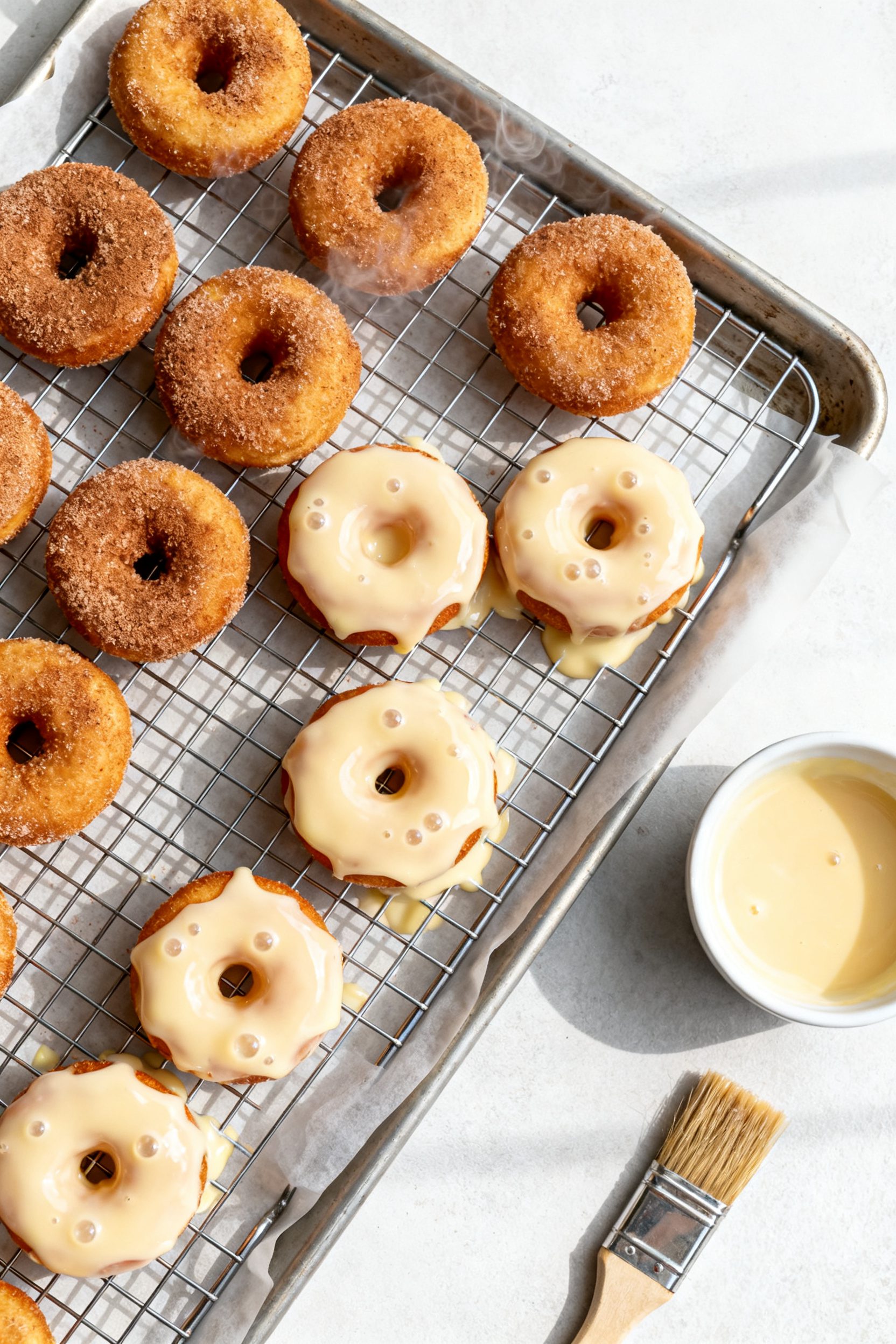 Overhead “tasty top view”: Assorted mini donuts on a wire rack set over a parchment-lined sheet 