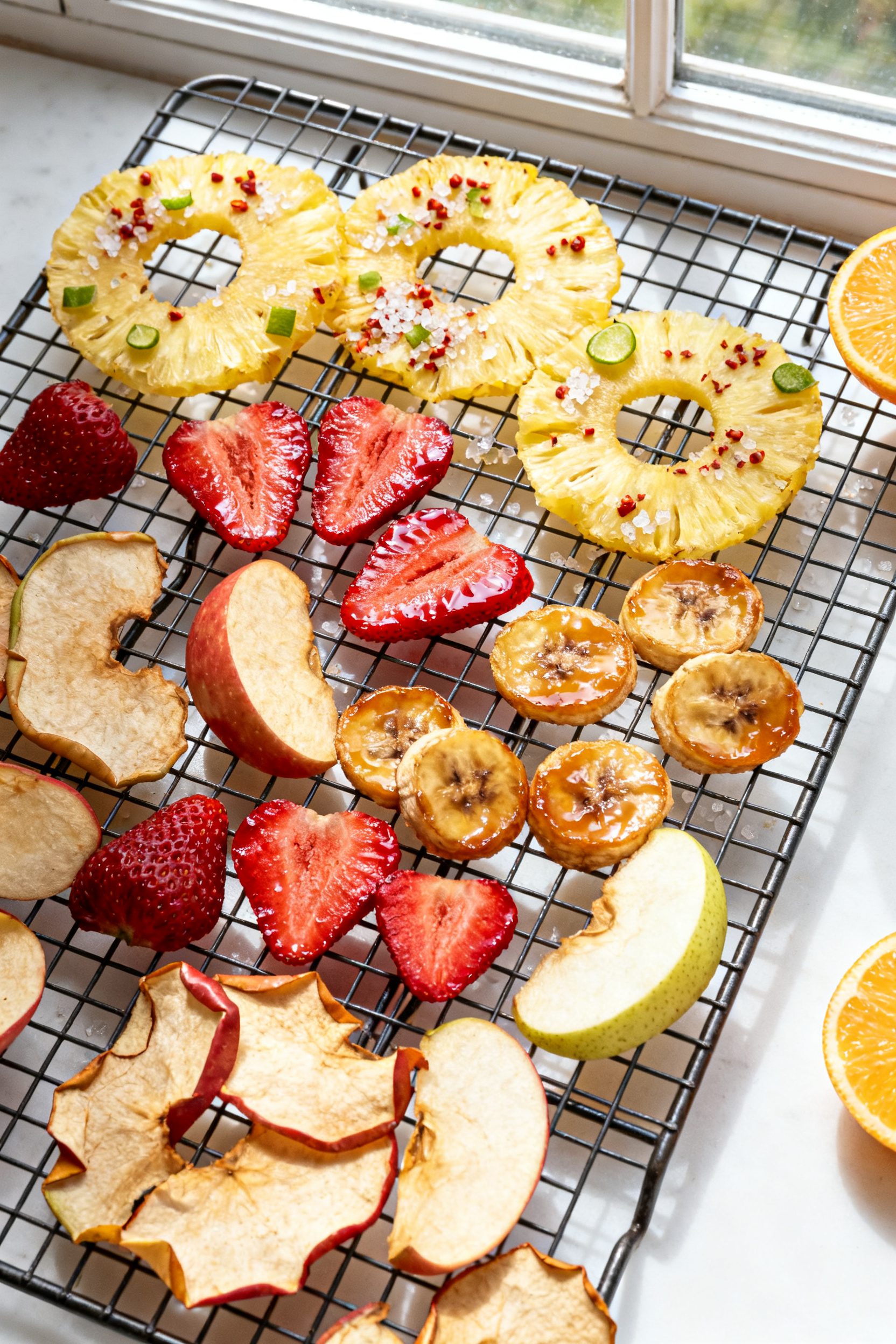 Tasty top view: Overhead shot of a mixed fruit chip spread cooling on a wire rack—paper-thin pinea