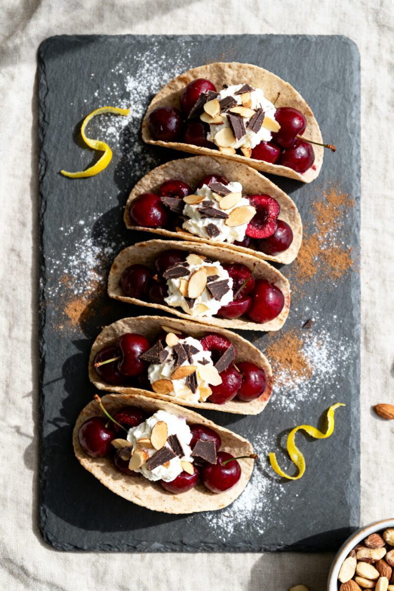 Tasty top view: Overhead shot of assembled Air Fryer Cherry Tacos arranged in a staggered row on a m