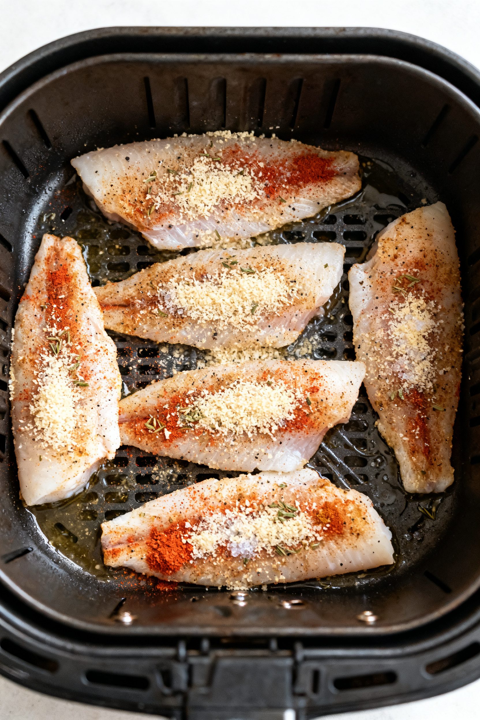 Tasty top view process shot: Overhead shot of seasoned white fish fillets arranged in a single layer