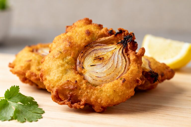 Air fryer onion bhaji with crispy golden onion fritters, tender onion layers, lightly spiced batter, fresh cilantro, and a lemon wedge, served as a flavorful Indian inspired appetizer.