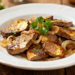 Air fryer liver and onions with tender browned liver slices, caramelized onions, fresh parsley garnish, and rich savory flavor, served as a classic comfort food dinner.