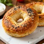 Air fryer keto bagels with a golden browned crust, chewy low carb texture, everything bagel seasoning, and cream cheese, served as a healthy breakfast or snack.