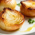 Air fryer baked whole onions with caramelized golden layers, tender sweet centers, fresh parsley, and a drizzle of olive oil, served as a simple and flavorful vegetable side dish.
