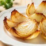 Air fryer onion petals with crispy golden roasted onion wedges, caramelized edges, tender sweet centers, and a creamy dipping sauce, served as an easy appetizer or flavorful side dish.
