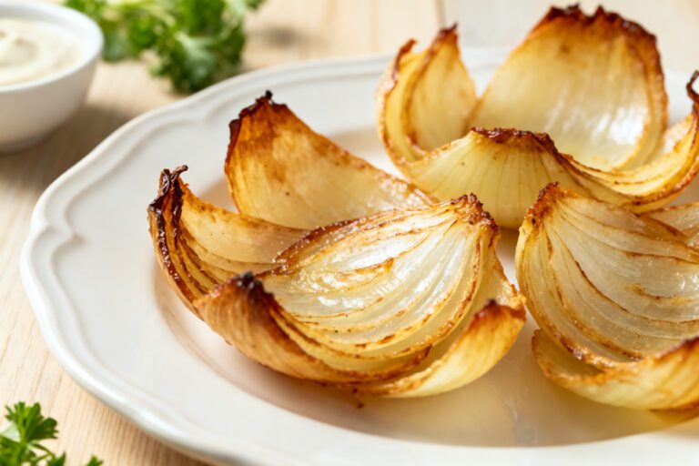 Air fryer onion petals with crispy golden roasted onion wedges, caramelized edges, tender sweet centers, and a creamy dipping sauce, served as an easy appetizer or flavorful side dish.