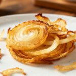 Air fryer dehydrated onions with thin dried onion rings, lightly golden edges, crisp texture, and concentrated flavor, served as a homemade pantry staple for cooking and seasoning.