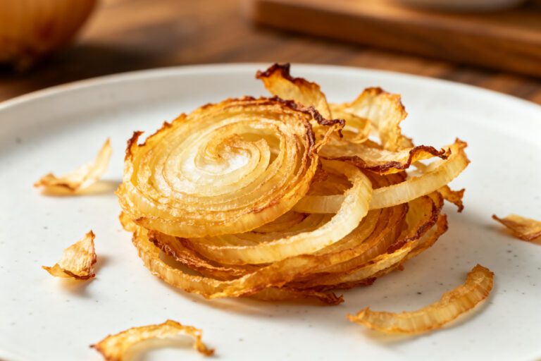 Air fryer dehydrated onions with thin dried onion rings, lightly golden edges, crisp texture, and concentrated flavor, served as a homemade pantry staple for cooking and seasoning.