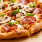 Air fryer keto pizza with a crispy golden low carb crust, melted mozzarella cheese, pepperoni, mushrooms, green bell peppers, and rich tomato sauce, served as a cheesy keto friendly dinner.