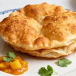 Air fryer easy Indian fry bread with golden puffy fried bread, crispy blistered exterior, soft fluffy interior, fresh cilantro, and mango chutney, served as a warm homemade side or snack.