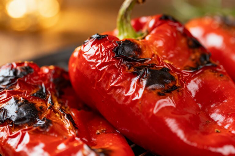 Air fryer roasted red peppers with blistered charred skins, tender sweet roasted peppers, and smoky flavor, served as a versatile ingredient for sandwiches, salads, pasta, or Mediterranean dishes.