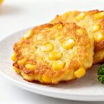 Air fryer corn fritters with crispy golden edges, sweet corn kernels, fluffy centers, and fresh parsley, served as an easy homemade appetizer or side dish.