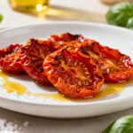 Air fryer sun dried tomatoes with chewy roasted tomato halves, concentrated sweet flavor, olive oil, and flaky sea salt, served as a homemade pantry staple.