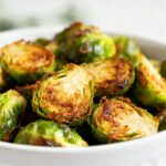 Air fryer smashed Brussels sprouts with crispy caramelized edges, tender centers, golden roasted surfaces, and savory garlic flavor, served as an easy healthy vegetable side dish.
