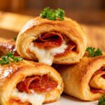 Air fryer pepperoni rolls with crispy golden dough, gooey melted mozzarella cheese, savory pepperoni slices, and fresh parsley, served as an easy cheesy snack or appetizer.