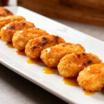 Air fryer gluten free chicken nuggets with crispy golden breading, juicy tender chicken, and a sweet dipping sauce, served as an easy gluten free appetizer or family meal.
