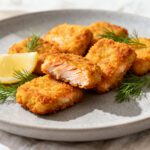 Air fryer salmon nuggets with crispy golden breading, tender flaky salmon, fresh dill, and lemon wedges, served as an easy high protein seafood meal.