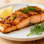 Air fryer brown sugar salmon with flaky salmon fillet, caramelized brown sugar glaze, fresh dill, and lemon wedges, served as a sweet and savory seafood dinner.