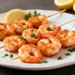 Air fryer shrimp skewers with juicy seasoned shrimp, lightly crispy edges, fresh parsley, and lemon wedges, served as an easy high protein seafood dinner.