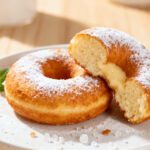 Air fryer mochi donut with a chewy soft interior, lightly golden exterior, powdered sugar, and a light fluffy texture, served as an easy homemade dessert.