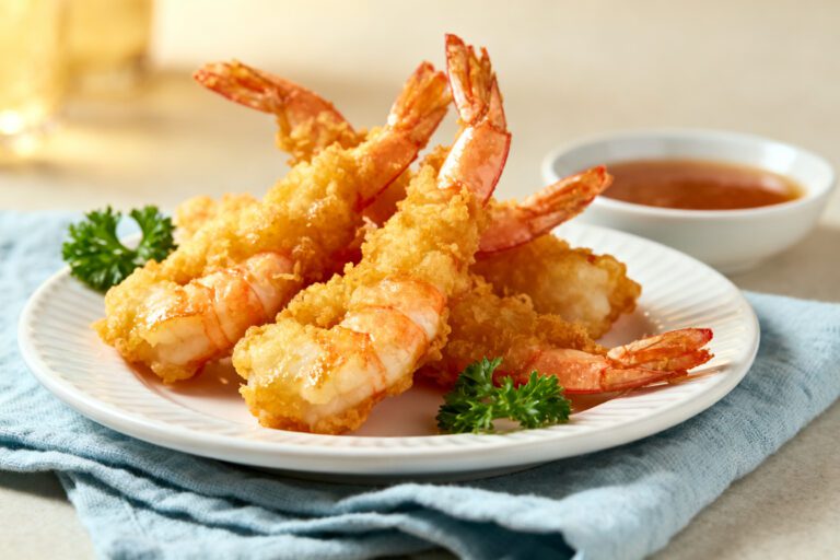 Air fryer tempura shrimp with a light crispy golden tempura coating, juicy tender shrimp, fresh parsley, and dipping sauce, served as an easy seafood appetizer.