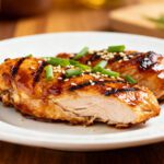 Air fryer chicken teriyaki with juicy grilled chicken, glossy teriyaki glaze, sesame seeds, sliced green onions, and caramelized edges, served as an easy weeknight dinner.