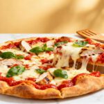 Air fryer pita pizza with a crispy pita crust, rich tomato sauce, melted mozzarella cheese, grilled chicken, and fresh basil, served as an easy homemade pizza.