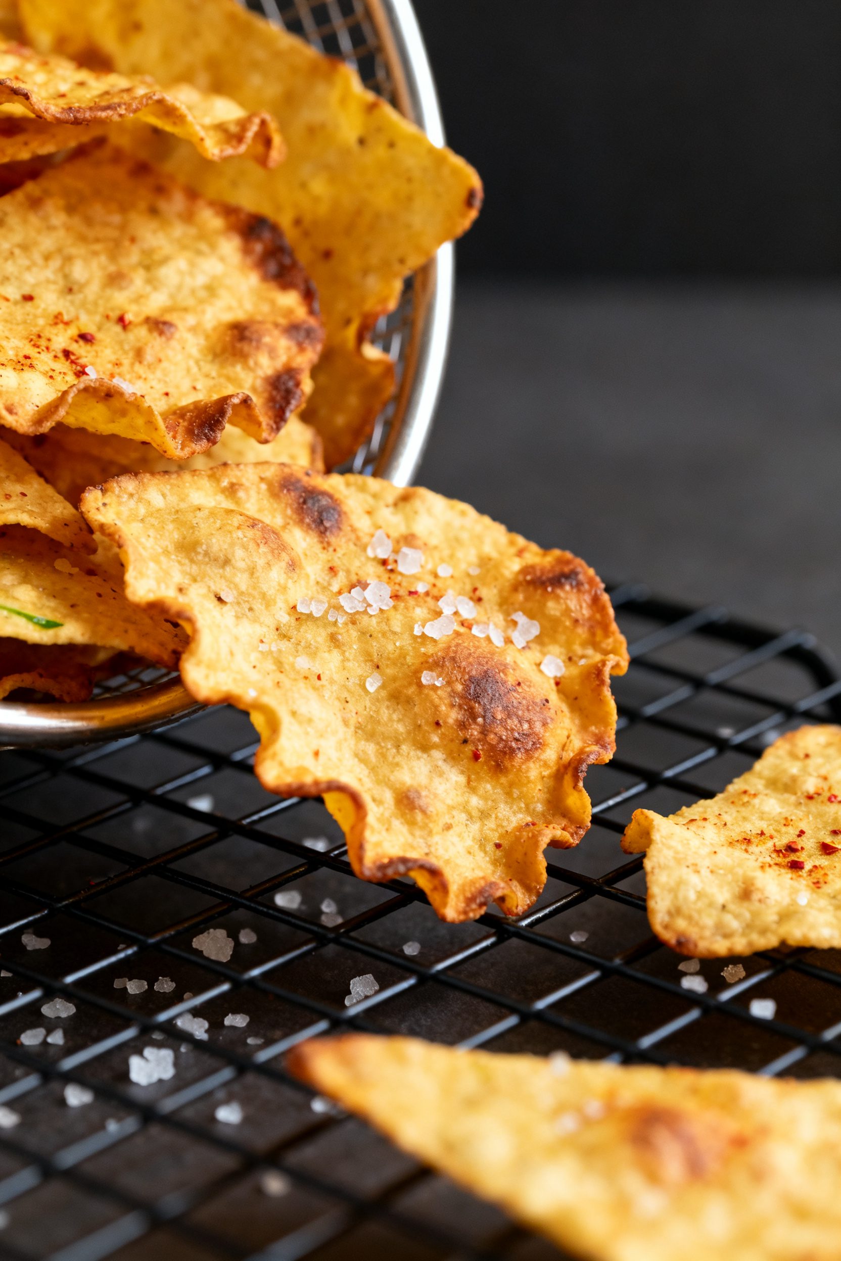 Close-up detail: Golden, air-fried low carb tortilla chips just out of the basket, highlighting blis