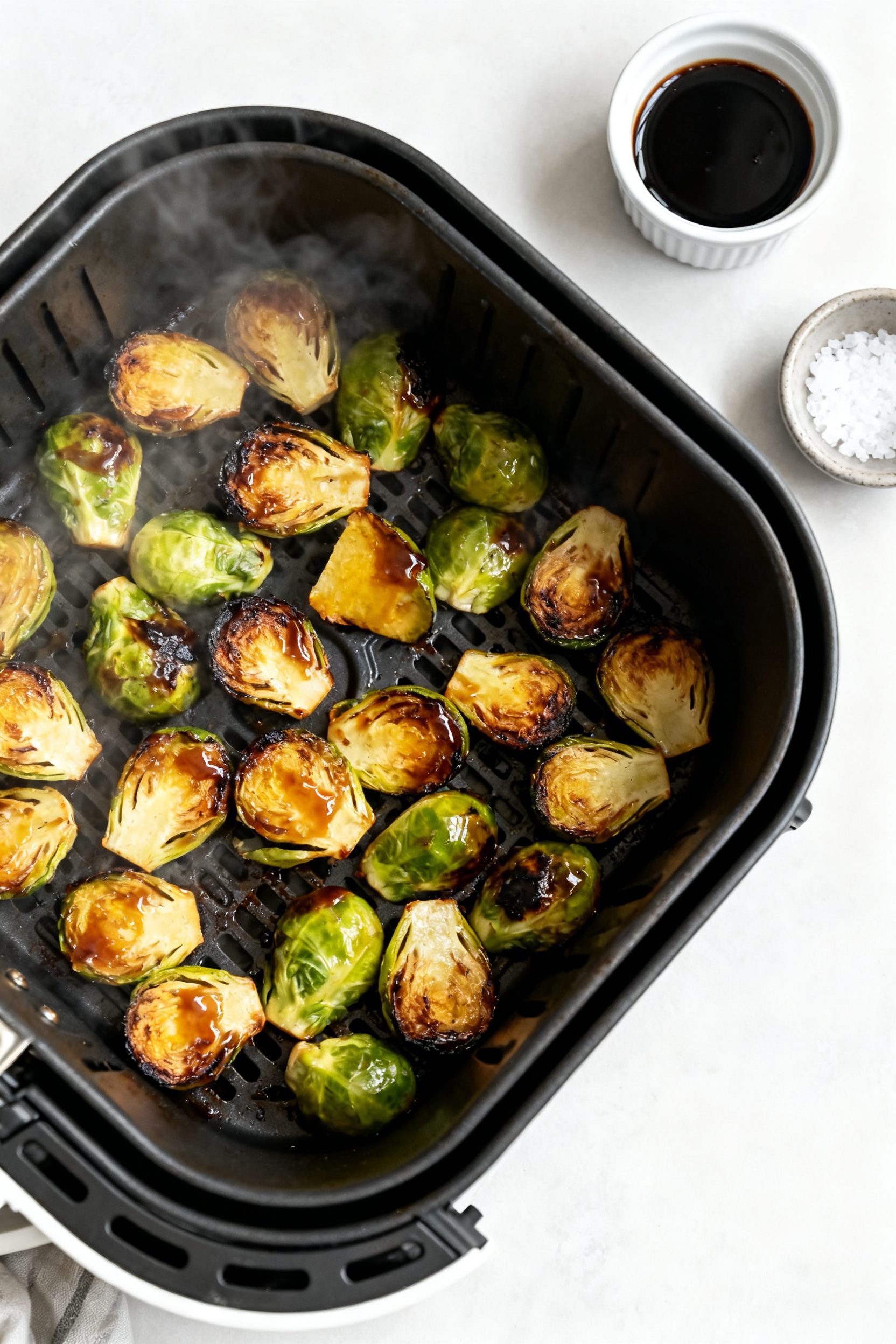Cooking process: Overhead shot of the air fryer basket mid-cook at 380°F after a shake, showing an
