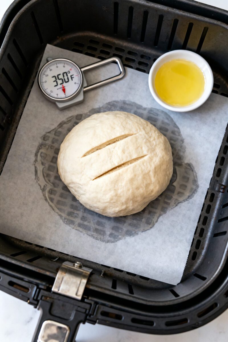 Cooking process: Overhead shot of the shaped 6–7 inch boule on lightly oiled parchment in the air